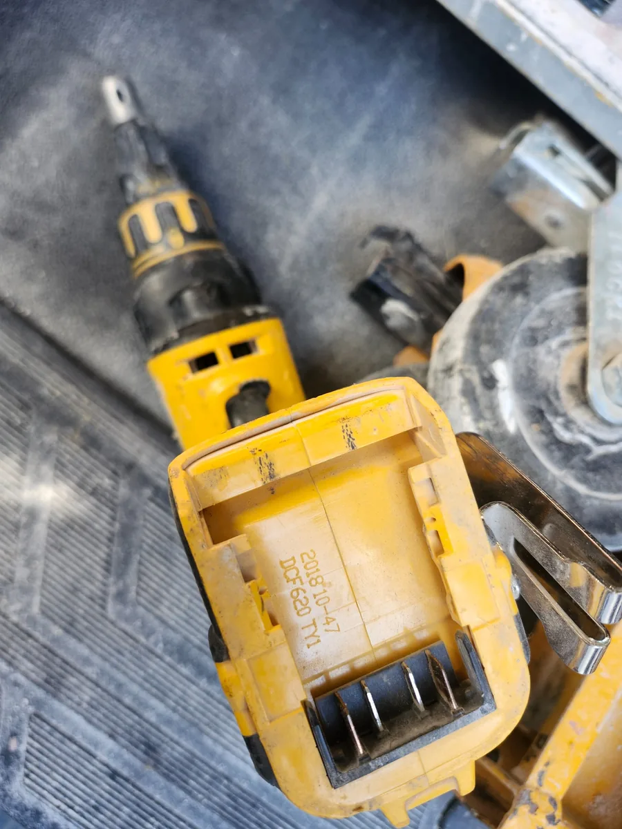 A field-used older-generation DEWALT cordless drywall screwgun showing years of jobsite use.