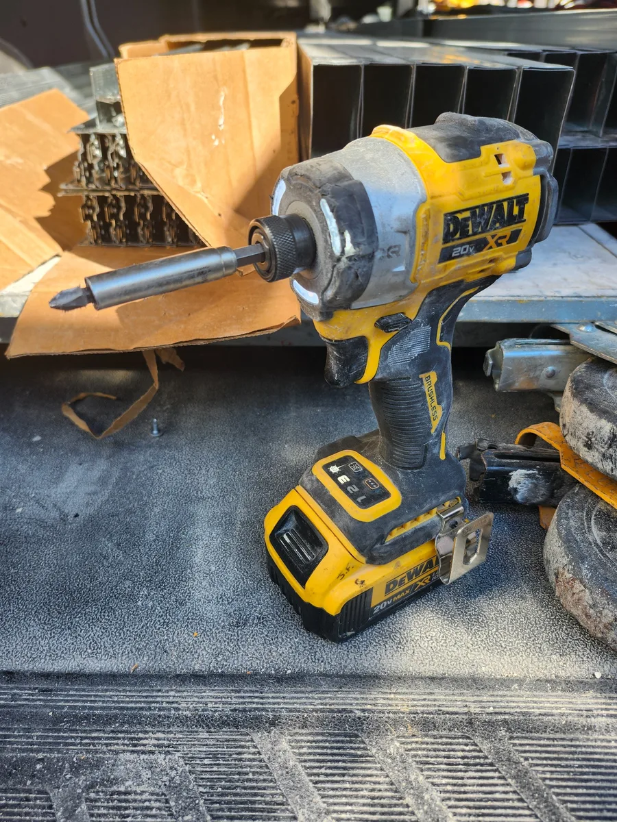 A well-used DEWALT cordless impact driver showing normal jobsite wear.