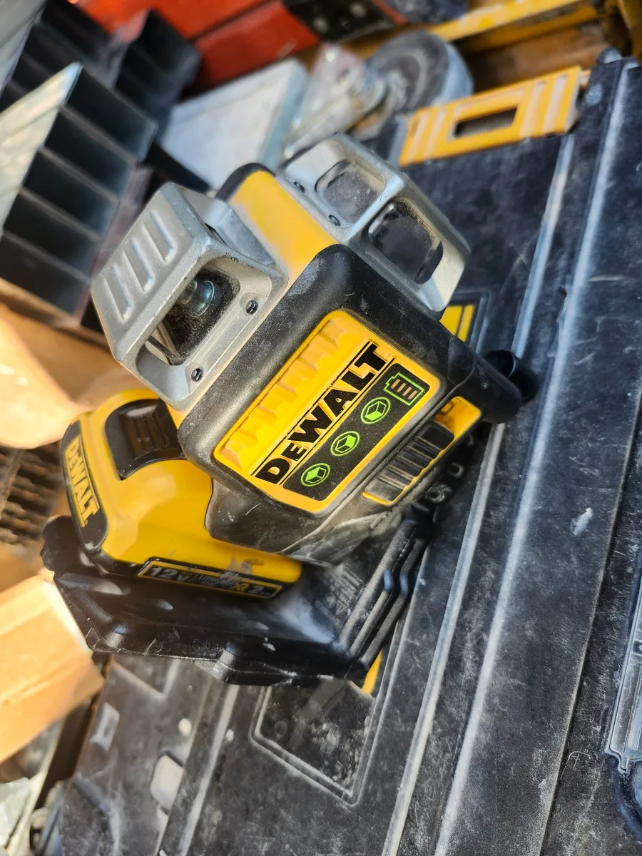 A field-used DEWALT green-line laser in its case.