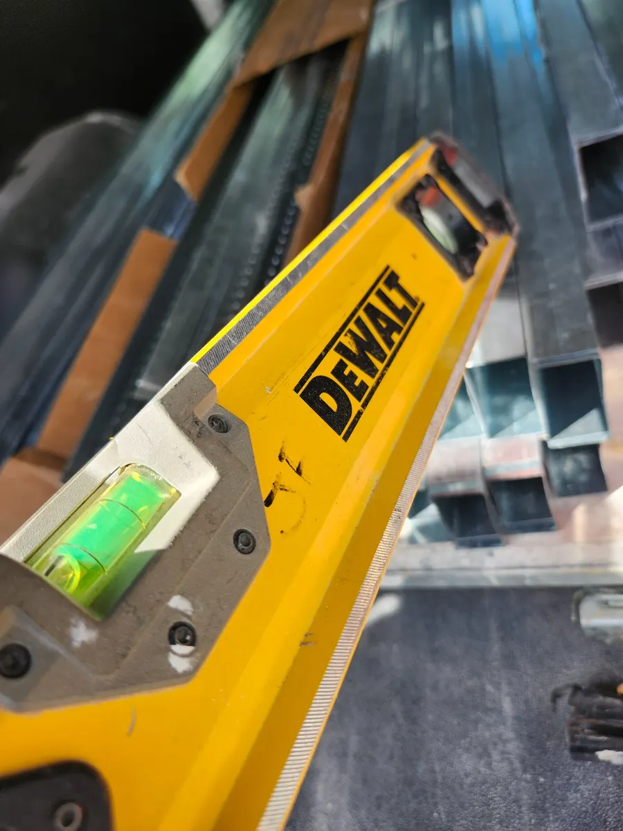 My field-used DEWALT DWHT43224 24-inch box beam level photographed with metal framing material.