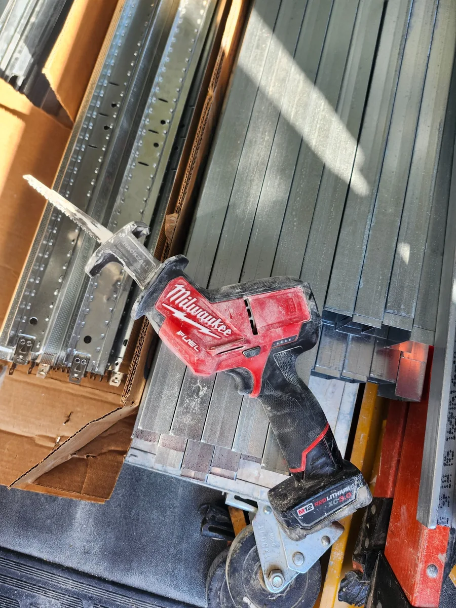 A field-used Milwaukee M12 FUEL Hackzall resting on metal framing material.